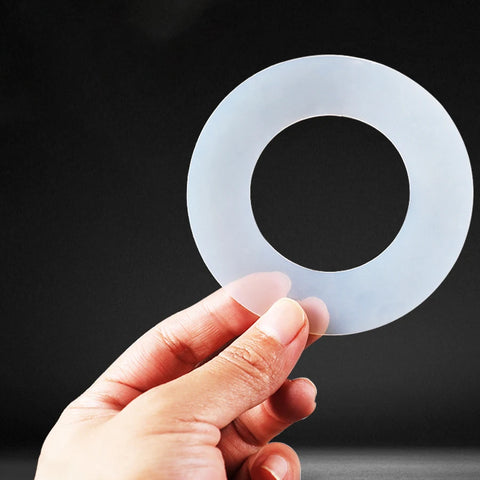 A hand holding a white, high-performance PTFE seal for a critical aerospace engine application.